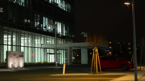 Modern gebouw en mensen verlaten het gebouw kantoor - tijd - geparkeerde auto stoppen — Stockvideo