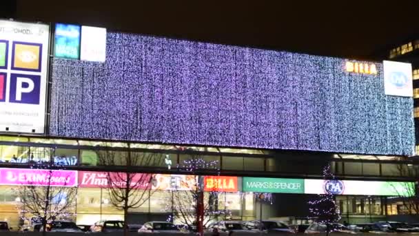 Edifício (shopping center) luzes de Natal com carros - noite - árvore urbana decorada com luzes de Natal — Vídeo de Stock