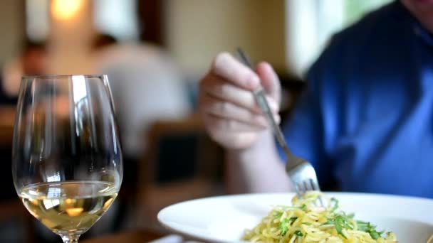 Restaurant - man eet spaghetti - wijn - mensen in achtergrond — Stockvideo