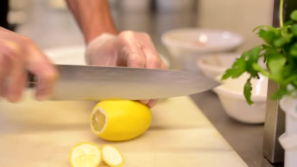 Chef-kok plakjes citroen in restaurant keuken — Stockvideo