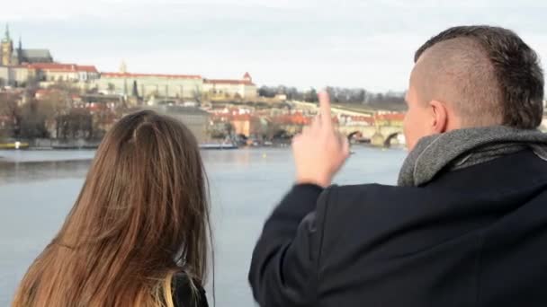 Gelukkige paar bekijken de monumenten op de brug - stad (Praag) op achtergrond — Stockvideo