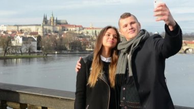 Yanında smartphone (selfie) - şehir (Prag) arka planda Köprüsü - erkek ve kadın aşık genç mutlu çift fotoğraf çekimi