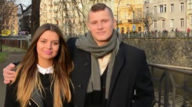 Mutlu çift şehirde yürümek ve Kameraya gülümse