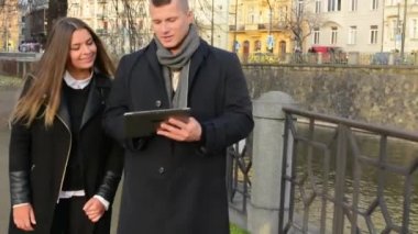 Mutlu çift tablet üzerinde çalışmak ve şehirde yürümek