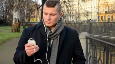 Genç yakışıklı adam akıllı - yürüyüş ve dinlediği müzik şehir