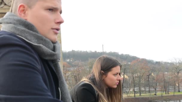 Unglückliches Paar auf Brücke in der Stadt - Park im Hintergrund — Stockvideo