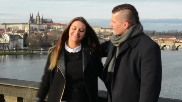 Šťastný pár vysoké pět a úsměv do kamery - město (Praha) v pozadí
