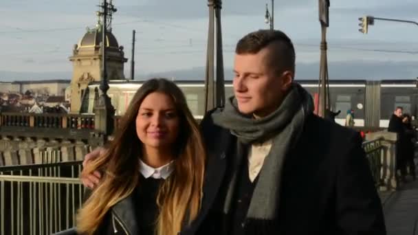 Jonge model paar in liefde lopen in de stad - park - sunny - brug met auto's en mensen op achtergrond — Stockvideo