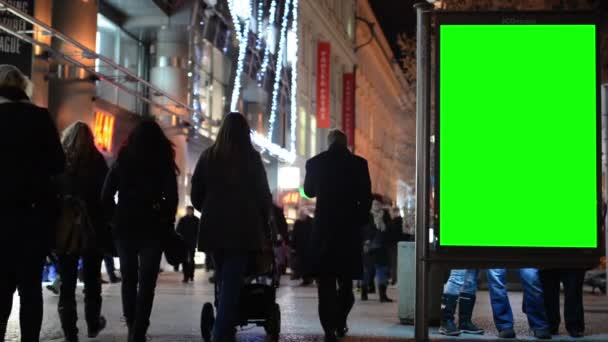 Panneau d'affichage dans la ville - rue urbaine avec bâtiments - écran vert - personnes à pied - nuit — Video