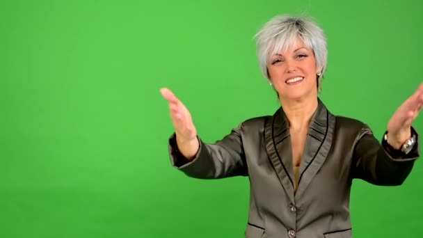Empresa mujer de mediana edad da la bienvenida - pantalla verde - estudio — Vídeo de stock