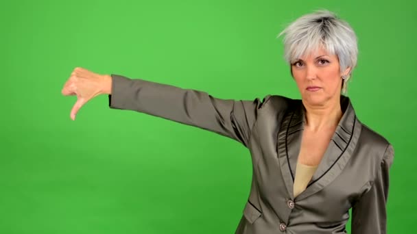 Business middle aged woman shows thumb on disagreement - green screen - studio