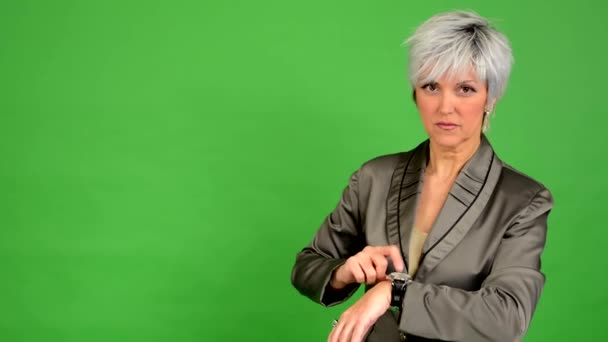Бизнес женщина средних лет указывает на то, что нужно смотреть - зеленый экран - студия — стоковое видео