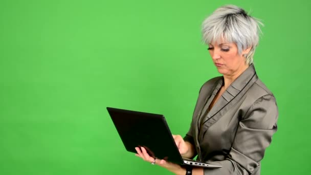 Empresa mujer de mediana edad trabaja en el cuaderno (de pie) - pantalla verde - estudio — Vídeos de Stock