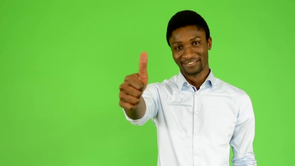 Joven hombre negro guapo muestra el pulgar en acuerdo - pantalla verde - estudio — Vídeos de Stock