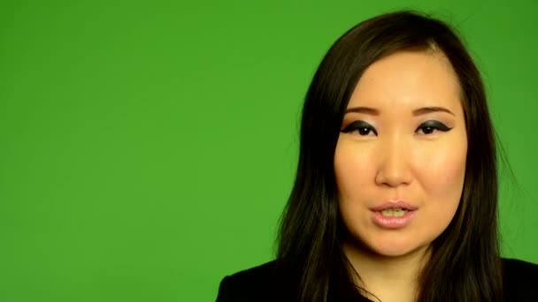 Молода приваблива азіатська жінка говорить - студія зеленого екрану крупним планом — стокове відео