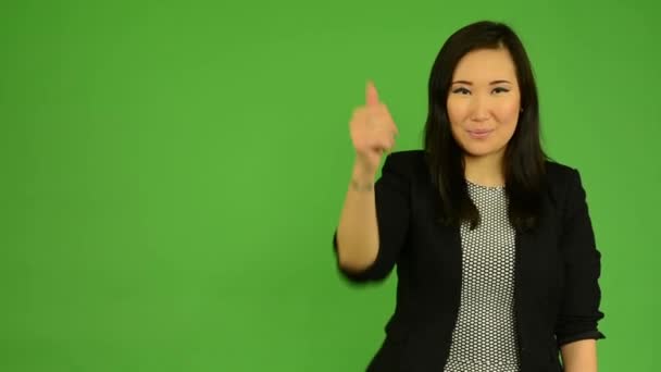 Junge attraktive asiatische Frau zeigt Daumen auf Übereinkunft - green screen studio — Stockvideo