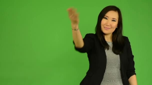 Jonge aantrekkelijke Aziatische vrouw nodigt - groen scherm studio — Stockvideo