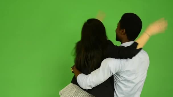 Счастливая пара радуется - черный мужчина и азиатская женщина - зеленый экран студии — стоковое видео