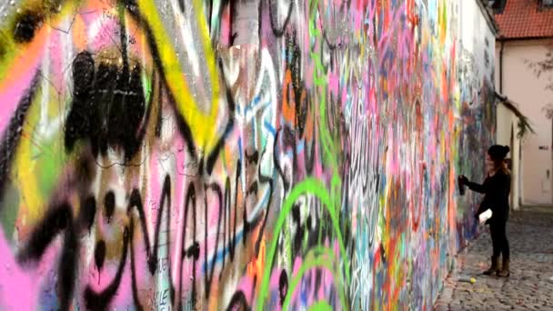Lennon Wall com pessoas - mulher pulverizada — Vídeo de Stock