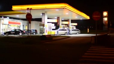 Gece şehri - ile arabalar ve insanlar - benzin istasyonu (yağ pompası) kabuğunda