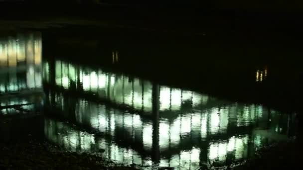 Reflexión en un estanque - edificios de negocios (oficinas) - noche - ventanas con luces - ciudad - timelapse — Vídeo de stock