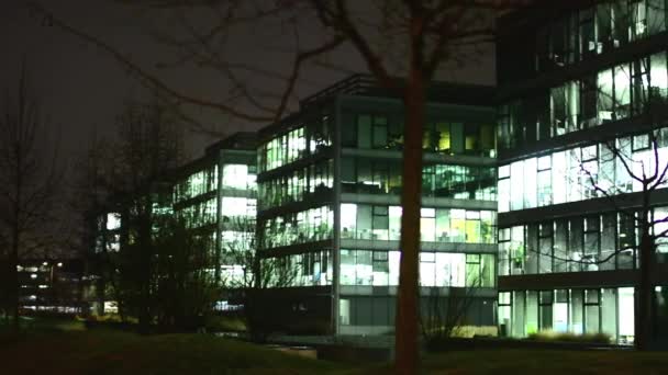 Geschäftsgebäude (Büros) - Nacht - Fenster mit Licht - Stadt - Bäume — Stockvideo