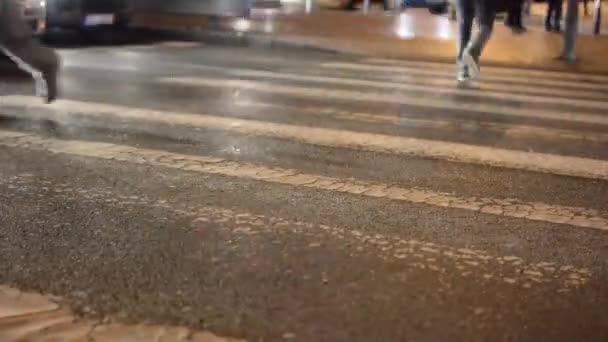 Strada urbana con auto - persone attraversano la strada - attraversamento pedonale - ombre di persone - notte - primo piano sulle gambe - timelapse — Video Stock