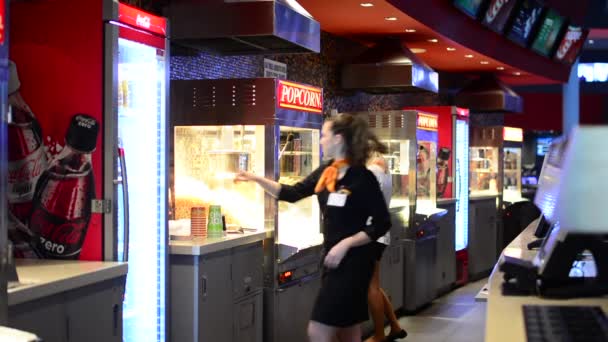 Bar in the cinema with saleswoman - saleswoman serves customers - takes poprcorn to container — Stock Video