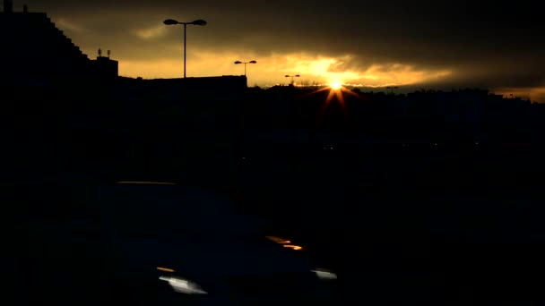 Solnedgång över staden - siluett - väg med bilar (strålkastare) - timelapse — Stockvideo