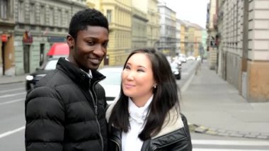 Mutlu çift kamera - zenci ve Asyalı kadın - kentsel sokak araba ile gülümse