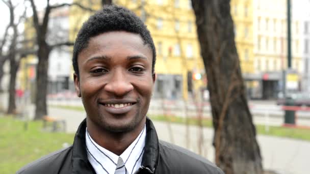 Young handsome black man smiles - urban street with cars - city - closeup — Stock Video