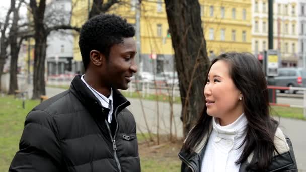 Happy couple talk (conversation) - black man and asian woman - urban street with cars - city — Stock Video