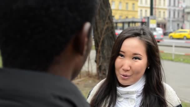 Feliz pareja hablar (conversación) - negro hombre y asiático mujer - urbano calle con coches - ciudad - disparo en asiático mujer — Vídeos de Stock