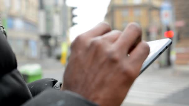 Schwarzer arbeitet an Tablet - Stadtstraße mit Autos - Stadt - Nahaufnahme (Schuss an der Hand)) — Stockvideo