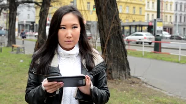 Jovem atraente mulher asiática trabalha em tablet - rua urbana com carros - cidade — Vídeo de Stock