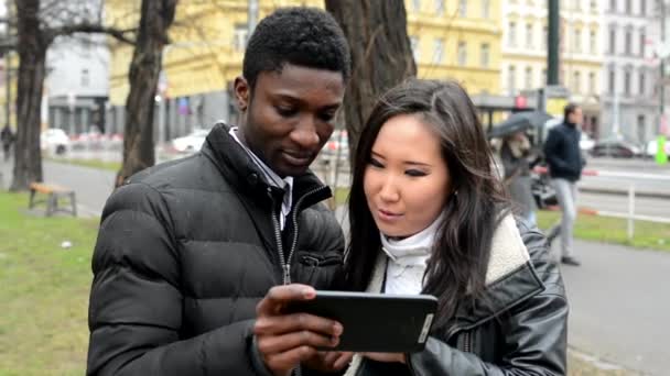 Feliz pareja de trabajo en la tableta - hombre negro y mujer asiática - calle urbana con coches - ciudad — Vídeos de Stock