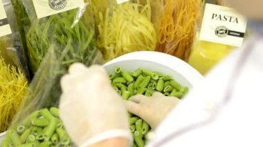 Şef kurutulmuş makarna çanta - fabrika - closeup koyar.