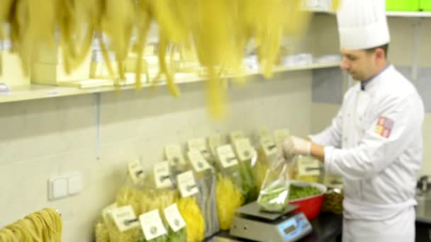 Chef-kok zet gedroogde pasta in zakken - fabriek — Stockvideo