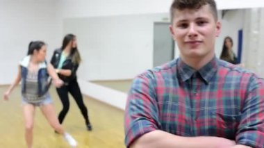 Yakışıklı adam (dansçı) gülümsüyor kamera - iki kadın arka planda dans - Hall