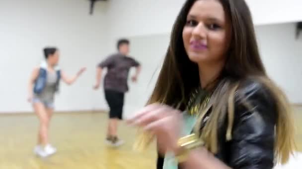 Jonge aantrekkelijke vrouw dans voorkant van camera - twee dansers dansen op achtergrond - hall — Stockvideo