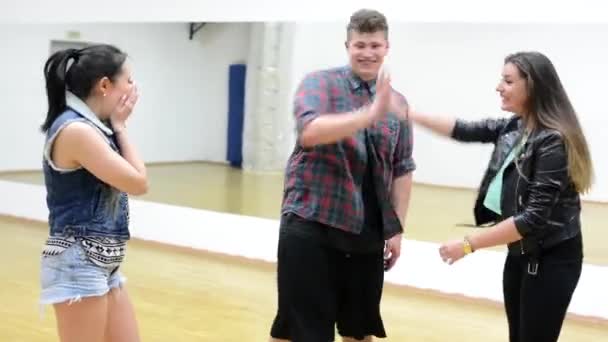 Group of three friends (dancers) joy - two women and one man - jump in circle  - hall — Stock Video