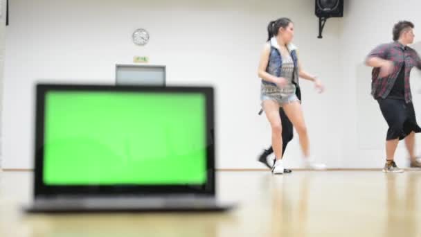 Notebook - groene scherm - drie dansers - groep van drie vrienden dansen in de achtergrond - twee vrouwen en een man - hall — Stockvideo