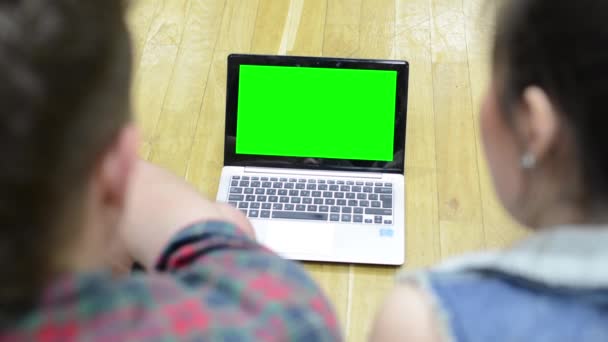 Twee vrienden (dansers) werken op de computer (laptop) - groen scherm - man en Aziatische vrouw — Stockvideo