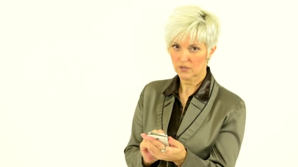 Mulher de meia-idade de negócios trabalha no smartphone (cara séria) - fundo branco - estúdio — Vídeo de Stock