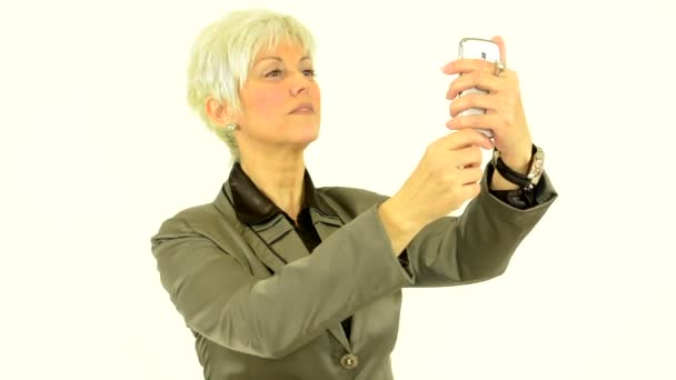 Business middle aged woman photographs with phone (smartphone) - white background - studio — Stock Video