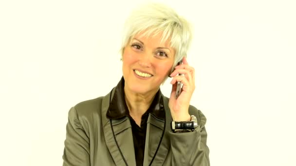 Бизнес женщина средних лет телефон и улыбки - женщина смотрит в камеру - белый фон - студия — стоковое видео