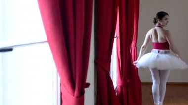 Genç balerin koridorda dans ve pencere - kırmızı perde dışında görünüyor