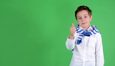 Genç yakışıklı çocuk çocuk bir başparmak sözleşmesi - yeşil ekran - studio gösterir.