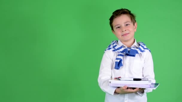 Jeune beau garçon enfant tient des manuels et sourit à la caméra - écran vert - studio — Video