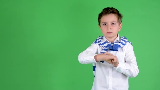 Young handsome child boy shows on time (watch) - green screen - studio — Stock Video